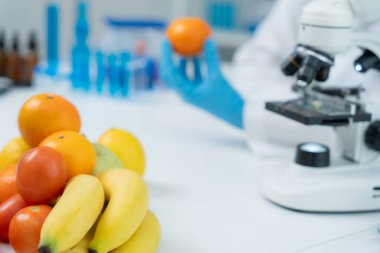 Scientist check chemical food residues in laboratory. Control experts inspect quality of fruits, vegetables. lab, hazards, ROHs, find prohibited substances, contaminate, Microscope, Microbiologist