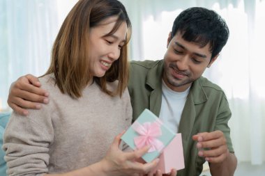 Güzel Asyalı kadın şaşırdı ve ilgi çekici hediye kutusuna baktı. Sevimli kız hediye kutusunu açtı. Doğum günü, kutlama, xmas, yeni yıl festivali, teşekkür, kutlama, sevgililer günü, yıldönümü
