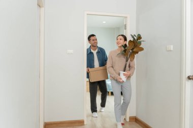 Taşınmak, taşınmak. Çiftler yeni bir ev için karton kutuda ekipman bulunduruyorlardı. Odanın içinde kişisel eşyalar ve mobilyalar içeren bir karton kutu vardı. Daireye taşın.
