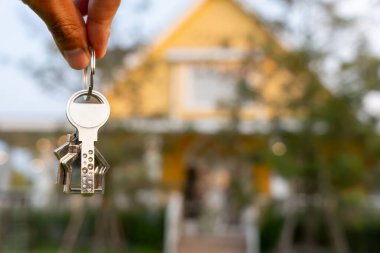 Kira, kiralama ve ev satma. Emlakçının elinde yeni bir ev ya da emlak için anahtar var. kira, satış, kredi finans, sigorta, satıcı, dağıtıcı, taksit, satın alma, satma, taşınma