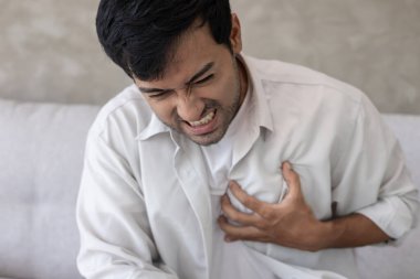 Göğüs kafesinde kalp krizi belirtileri var. Asyalı bir adamın göğüs ağrısı var. Kalp rahatsızlığı, sızıntı, genişleme, kalp büyümesi, göğsüne acı verici bir ifadeyle bastırma.