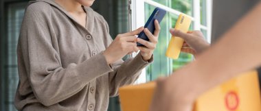 Gülümse Asyalı kadın yemek parası için QR kodunu tara. Teslimatçı ekspres teslimat gönderdi. Çevrimiçi dükkan, kağıt konteynır, paket servis, paket, elektronik para, dijital aktarım