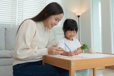 Mutlu anne küçük kız için boya öğreniyor. Komik aile evde mutlu ve heyecanlı. Anne ve kızı birlikte vakit geçiriyorlar. Tatil, etkinleştir
