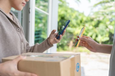 Mutlu bir gülümseme Asyalı kadın yemek parası için QR kodunu tarıyor. Teslimatçı ekspres teslimat gönderdi. Çevrimiçi dükkan, kağıt konteynır, paket servis, paket, elektronik para, dijital transfer