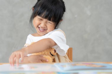 Mutlu Asyalı çocuklar evde kitap okuyarak rahatlar. Kızım ve bir hikaye okuyordum. öğrenme, çocuk bakımı, gülme, eğitim, hikaye anlatma, uygulama, hayal etme, bağımlılık cep telefonunu azaltma