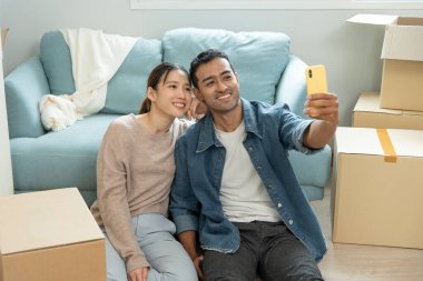 Taşınmak, taşınmak. Yeni ev eşyaları taşınırken birkaç selfie, odanın içinde kişisel eşyalar içeren bir karton kutu vardı. yeni daireye ya da daireye taşın