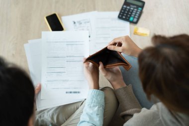 Stressed and headache asian couple with large bills or invoices no money to pay to expenses and business problem. shortage, Financial problems, mortgage, loan, bankruptcy, bankrupt, poor