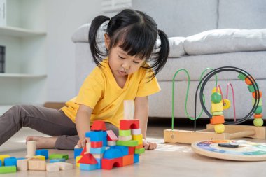 Mutlu Asya çocukları oyuncak bloklarıyla oynayıp öğreniyor. Aile evde mutlu ve heyecanlı. Kızın zaman, etkinlik, gelişme, IQ, EQ, meditasyon, beyin, kaslar, temel beceriler.