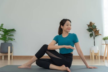 Evde ya da apartmanda yoga yapan zayıf bir kadın. Sabahları egzersiz yapan Asyalı bir kadın. denge, meditasyon, rahatlama, sakinlik, sağlık, mutluluk, rahatlama, sağlıklı yaşam tarzı, diyet, ince