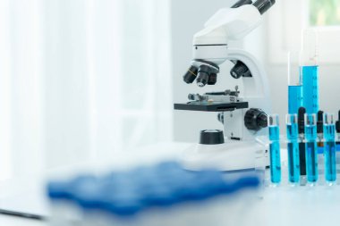 Bilimadamı ileri bilimsel laboratuvarda biyokimyasal örnekleri analiz ediyor. Tıbbi profesyonel kullanım mikroskobu virüsün mikrobiyolojik gelişimini gösteriyor. Bilim alanında biyoteknoloji araştırması.