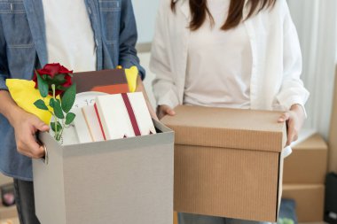 Taşınmak, taşınmak. Çiftler yeni bir ev için karton kutuda ekipman bulunduruyorlardı. Odanın içinde kişisel eşyalar ve mobilyalar içeren bir karton kutu vardı. Daireye taşın.