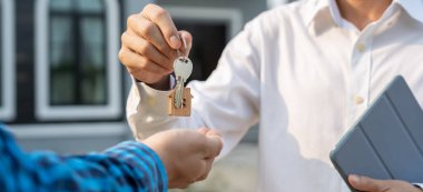 Kira, kiralama ve ev satma. Emlakçının elinde yeni bir ev ya da emlak için anahtar var. kira, satış, kredi finans, sigorta, satıcı, dağıtıcı, taksit, satın alma, satma, taşınma