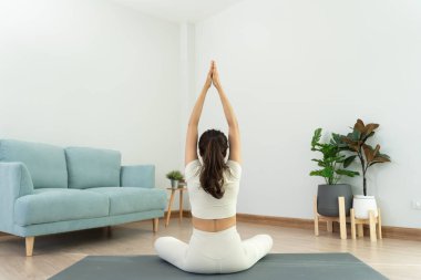 Evde ya da apartmanda yoga yapan zayıf bir kadın. Sabahları egzersiz yapan Asyalı bir kadın. denge, meditasyon, rahatlama, sakinlik, sağlık, mutluluk, rahatlama, sağlıklı yaşam tarzı, diyet, sli