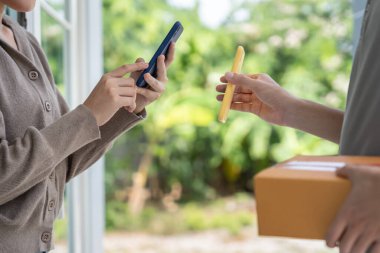 Mutlu bir gülümseme Asyalı kadın yemek parası için QR kodunu tarıyor. Teslimatçı ekspres teslimat gönderdi. Çevrimiçi dükkan, kağıt konteynır, paket servis, paket, elektronik para, dijital transfer