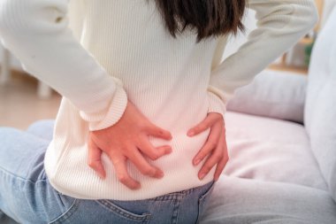 Sırtını inciten ve dayanılmaz ağrılar çeken bir kadın. Sağlık ve sorunlar, kronik sırt ağrısı, ofis sendromu, skolyoz, bel fıtığı, kas iltihabı.