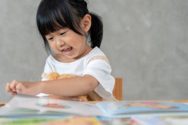 Mutlu Asyalı çocuklar rahatlayın ayı bebek için masal kitabı okuyun. Kızım ve bir hikaye okuyordum. öğrenim geliştirme, çocuk bakımı, eğitim, hikaye anlatma, uygulama, hayal etme, bağımlılığı azaltma cep telefonu