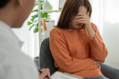 Akıl sağlığı sorunları olan bir kadın danışmanlık yapıyor. Psikiyatrist tedavi için hastanın durumunu kaydediyor. teşvik, sevgi ve aile sorunu, bipolar, depresyon hastası, intiharı koru