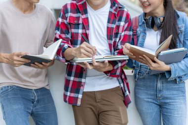Grup Asyalı öğrenci toplantı takımı iş projesi için. Mutlu çalışma takımı. Üniversite kampüsünde kitap oku. Uluslararası Asya Üniversitesi Grubu. Eğitim, öğrenim, okul, üniversite, mezuniyet