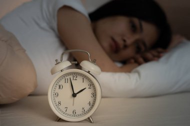 Asyalı kadın geç saatlere kadar uyumaya çalışıyor uykusuzluk çekiyor, uykusuzluk çekiyor ya da bir kabusta korkuyor üzgün endişeli ve stresli görünüyor. Yorgun ve baş ağrısı ya da gecenin bir yarısı uyanan migren..