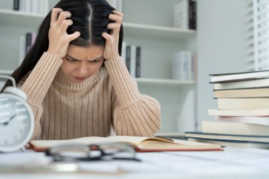 Asian student woman have anxiety because of exams, female prepare for test and learning lessons in the library. stress, despair, haste, misunderstanding reading, discouraged, expectation, knowledge