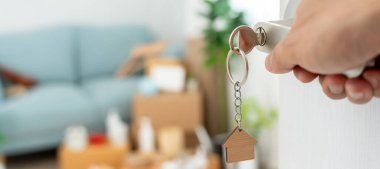 Taşınmak, taşınmak. Yeni dairede adam kapıyı açıyor. Yeni evine taşın. Emlak al ya da kirala. konut kirası, kiralık mülk, yeni ev sahibi, yatırım, konut, kredi, ipotek