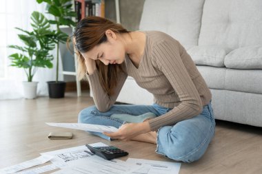Yüklü faturaları ve faturaları olan stresli ve baş ağrısı çeken Asyalı kadın harcamaları ve kredi kartı borçlarını ödeyecek parası yok. kıtlık, mali sorunlar, mortgage, kredi, iflas, iflas, yoksul, boş duvar