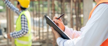 inspector or engineer is inspecting construction and quality assurance new house using a checklist. Engineers or architects or contactor work to build the house before handing it over to the homeowner