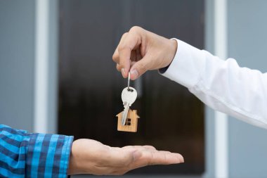 Kira, kiralama ve ev satma. Emlakçı menajeri yeni sahibine gülümsüyor. kira, satış, kredi finans, sigorta, satıcı, dağıtıcı, taksit, satın alma, satma, taşınma