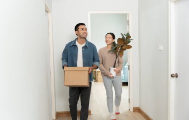 Taşınmak, taşınmak. Çiftler karton kutu taşıyorlar ve dekorasyon malzemelerini yeni apartman dairesi için içeriyor, odanın içinde kişisel eşyalar ve mobilyalar içeren bir karton kutu vardı. taşınan daire