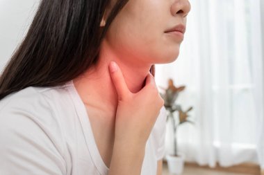 Asyalı kadın boğazı ağrıdığı için boynuna takıldı. Dişi bademcik iltihabı iltihaba neden olur. Su alarak, antibiyotik alarak, doktora, virüse, korona virüsüne, gribe, gribe danışarak tedavi olunur.