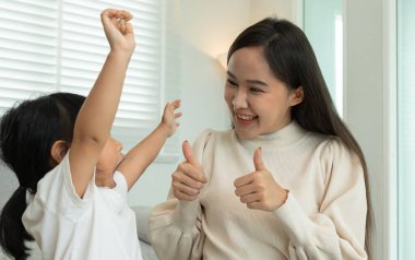 Anneler günü, mutlu anne küçük kızla oynuyor. Komik aile evde mutlu ve heyecanlı. Anne ve kızı birlikte vakit geçirirken eğleniyorlar. tatil, hafta sonu, IQ, EQ, meditasyon 