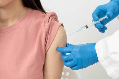 Kadın salgını önlemek için aşı oluyor. Tıp merkezindeki bir hemşire ya da doktordan bir doz bağışıklık aşısı al. Temel aşı, alternatif aşı, risk grubu aşısı.