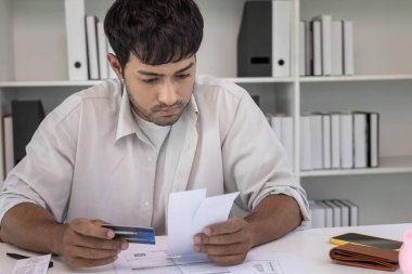 Yüklü faturaları ve faturaları olan stresli ve baş ağrısı çeken Asyalı bir adamın harcamaları ve kredi kartı borçlarını ödeyecek parası yok. kıtlık, mali sorunlar, mortgage, kredi, iflas, iflas, yoksul, boş cüzdan