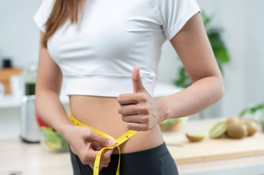 Diyet ve diyet. Güzel, ince kadın vücut ölçüsü. Spor elbiseli bir kadın sağlıklı yaşam için kilo verme hedefine, zayıflığa, ince belliye, beslenme uzmanına ulaşır.