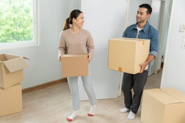 Taşınmak, taşınmak. Çiftler yeni bir ev için karton kutuda ekipman bulunduruyorlardı. Odanın içinde kişisel eşyalar ve mobilyalar içeren bir karton kutu vardı. Daireye taşın.