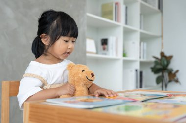 Mutlu Asyalı çocuklar evde kitap okuyarak rahatlar. Kızım ve bir hikaye okuyordum. öğrenme, çocuk bakımı, gülme, eğitim, hikaye anlatma, uygulama, hayal etme, bağımlılık cep telefonunu azaltma