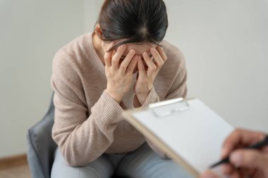 Akıl sağlığı sorunları olan bir kadın danışmanlık yapıyor. Psikiyatrist tedavi için hastanın durumunu kaydediyor. teşvik, sevgi ve aile sorunu, bipolar, depresyon hastası, intiharı koru