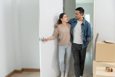 Taşınmak, taşınmak. Mutlu çift, içinde kişisel eşyalar ve mobilyalar olan bir karton kutu olan yeni bir ev ya da ev gösterdi. Daireye taşın..