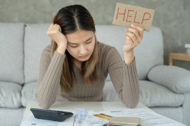 Yüklü faturaları ve faturaları olan stresli ve baş ağrısı çeken Asyalı kadın harcamaları ve kredi kartı borçlarını ödeyecek parası yok. kıtlık, mali sorunlar, mortgage, kredi, iflas, iflas, yoksul, boş cüzdan