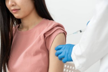 Kadın salgını önlemek için aşı oluyor. Tıp merkezindeki bir hemşire ya da doktordan bir doz bağışıklık aşısı al. Temel aşı, alternatif aşı, risk grubu aşısı.