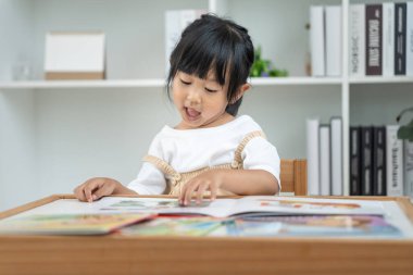 Mutlu Asyalı çocuklar evde kitap okuyarak rahatlar. Kızım ve bir hikaye okuyordum. öğrenme, çocuk bakımı, gülme, eğitim, hikaye anlatma, uygulama, hayal etme, bağımlılık cep telefonunu azaltma