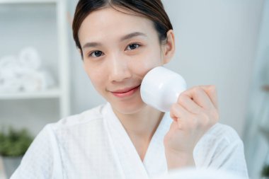 Güzel Asyalı kadınlar gözeneklerini sıkmak için aletler kullanır. Sağlıklı yüzler. Yüz bakımı ve tedavisi. Deri reklamı. Yüz kremi, kırışıklık önleyici, bebek yüzü, beyazlatma, nemlendirici, gözenek sıkılaştırıcı serum.