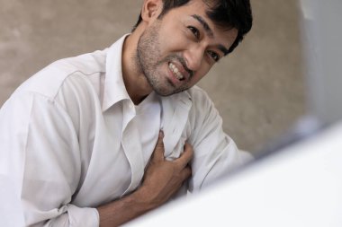 Göğüs kafesinde kalp krizi belirtileri var. Asyalı bir adamın göğüs ağrısı var. Kalp rahatsızlığı, sızıntı, genişleme, kalp büyümesi, göğsüne acı veren bir ifadeyle bastırma.