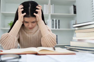 Asian student woman have anxiety because of exams, female prepare for test and learning lessons in the library. stress, despair, haste, misunderstanding reading, discouraged, expectation, knowledge