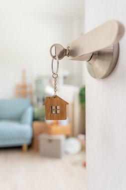 Moving house, relocation. The key was inserted into the door of the new house, inside the room was a cardboard box containing personal belongings and furniture. move in the apartment or condominium