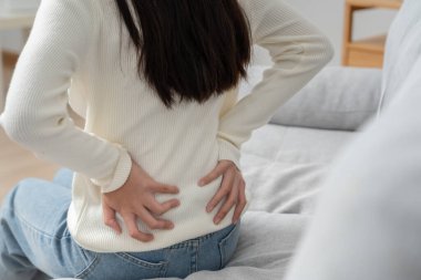 Kadın kendini tutuyor ve dayanılmaz ağrılar çekiyor. Sağlık ve sorunlar, kronik sırt ağrısı, ofis sendromu, skolyoz, bel fıtığı, kas iltihabı.