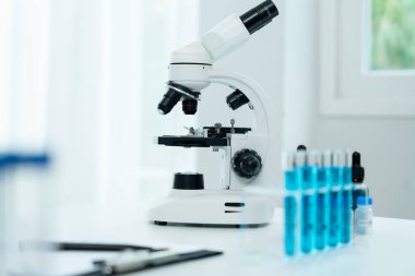 Bilimadamı ileri bilimsel laboratuvarda biyokimyasal örnekleri analiz ediyor. Tıbbi profesyonel kullanım mikroskobu virüsün mikrobiyolojik gelişimini gösteriyor. Fen laboratuvarında biyoteknoloji araştırması