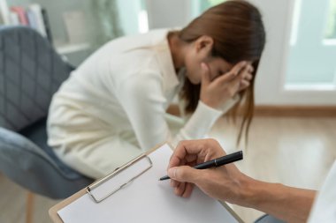 Akıl sağlığı sorunları olan bir kadın danışmanlık yapıyor. Psikiyatrist tedavi için hastanın durumunu kaydediyor. teşvik, sevgi ve aile sorunu, bipolar, depresyon hastası, intiharı koru