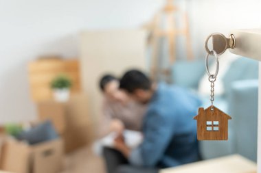 Moving house, relocation. The key was inserted into the door of the new house, inside the room was a cardboard box containing personal belongings and furniture. move in the apartment or condominium