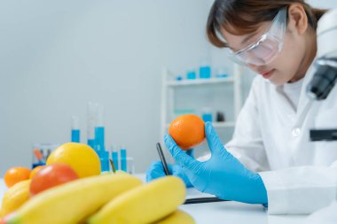 Bilimadamı laboratuvardaki kimyasal gıda kalıntılarını kontrol ediyor. Kontrol uzmanları meyve ve sebzelerin kalitesini inceler. Laboratuvar, tehlike, ROHs, yasaklı maddeleri bul, kirlet, mikroskop, mikrobiyoloji